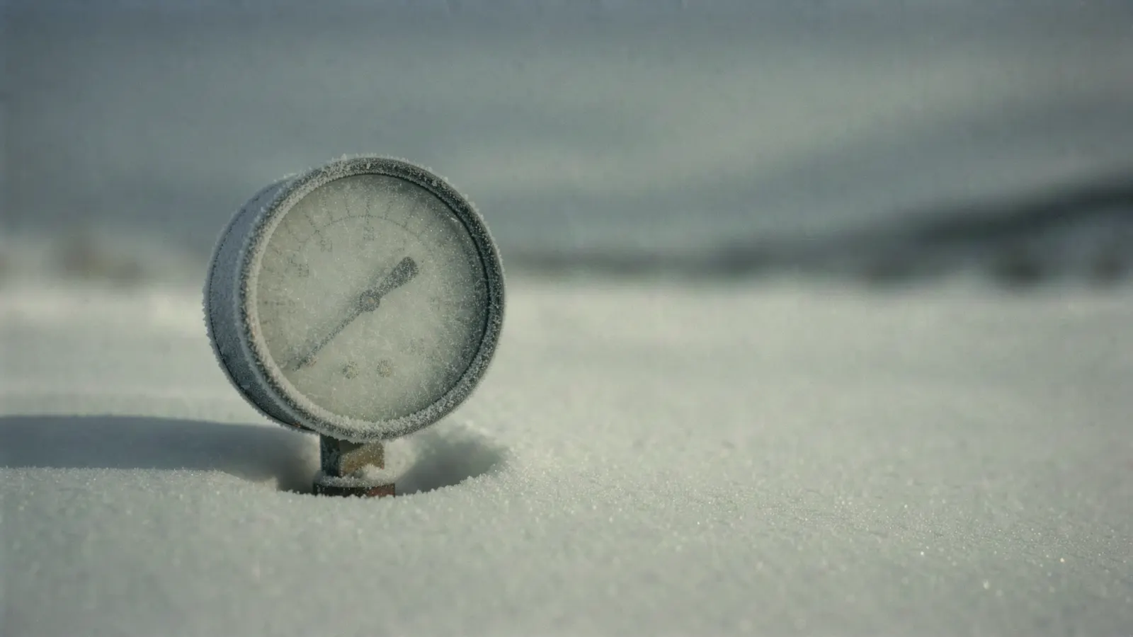 Abstract concentric arcs in muted pewter and pale frost tones, like a faded chart ring on cold paper