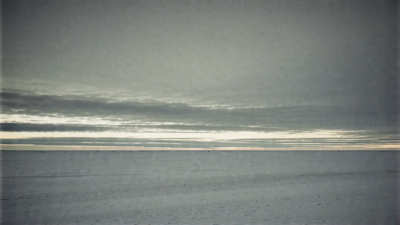 A thin band of pale morning light crossing cool slate-blue layers, quiet and clean